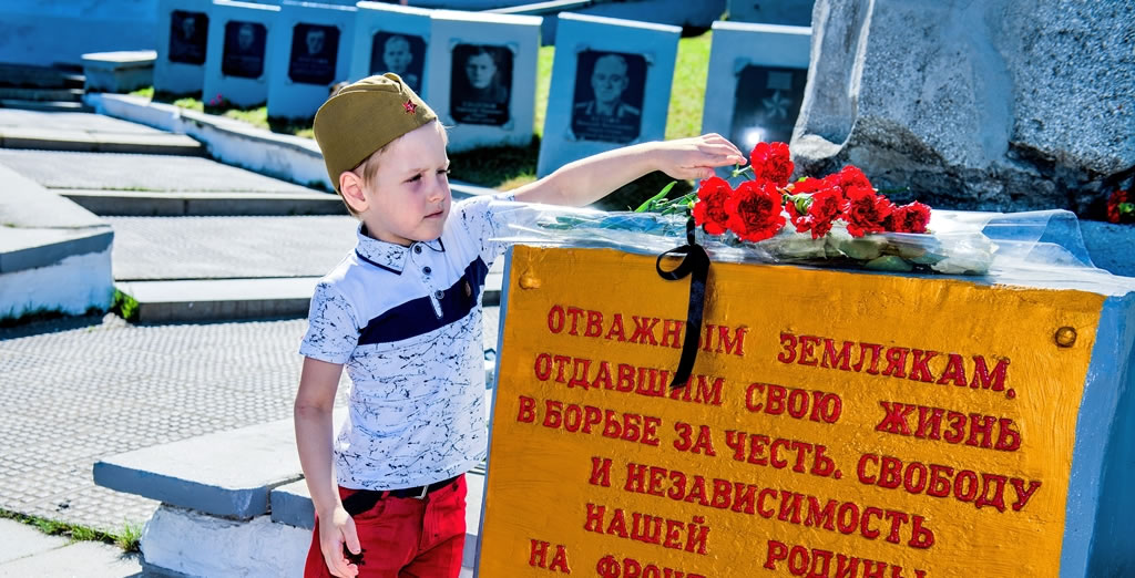 Правнук ветерана Константина Константиновича Волкова Дима возлагает цветы к главному мемориалу Нижней Туры