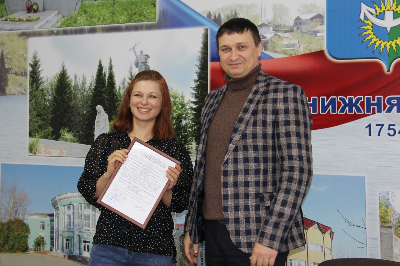 Счастливая обладательница жилищного сертификата Екатерина Король принимает поздравления от врио главы НТГО Андрея Постовалова