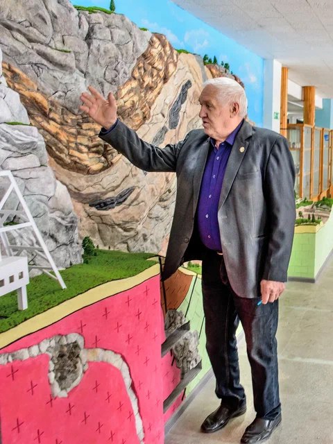 Александр Егорович Пудовкин показывает гостям уникальный объект – макет геологического обнажения для практики геологов и маркшейдеров, созданный в музее ИГРТ благодаря помощи компании «Полиметалл»