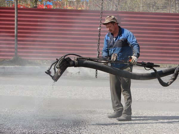 Работники ООО «Ремстройгаз» производят ремонт дороги методом пневмонабрызга асфальта